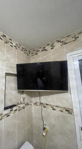 a flat screen tv hanging on a wall at Jamaican R Home in Kingston