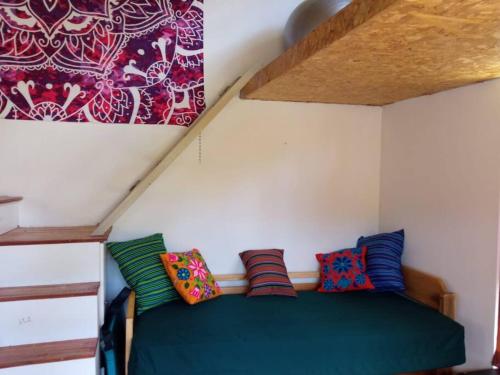 ein Schlafzimmer mit einem grünen Bett und bunten Kissen in der Unterkunft Casita Mayuc in Huaran