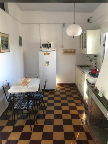 a kitchen with a table and a white refrigerator at Apartamento con garaje cerrado in Minas