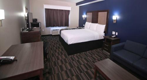 a hotel room with a bed and a couch at Home Inn and Suites Olive Branch in Olive Branch