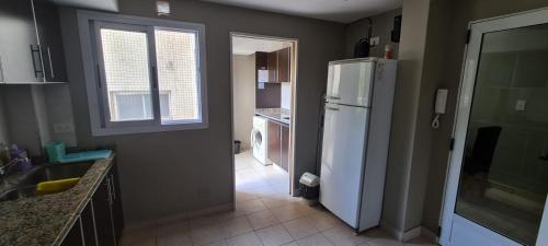 a kitchen with a white refrigerator and a window at Humberto Apart B in Luján