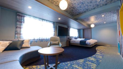 a hotel room with a couch and a bed at Grand Mercure Nasu Highlands Resort & Spa in Nasu