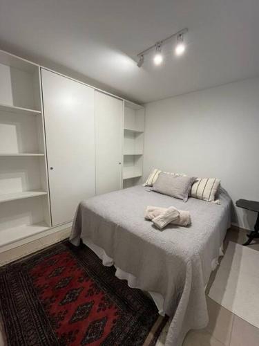 Habitación blanca con cama con alfombra en Depto nuevo zona Alto Rosario en Rosario