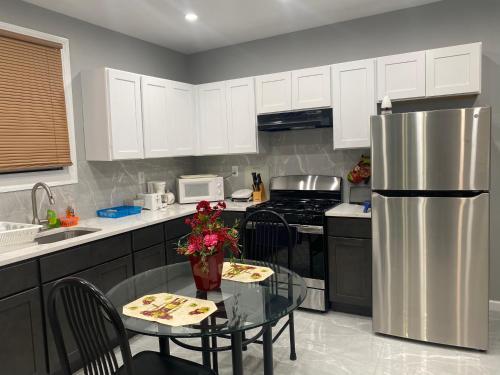 a kitchen with a table and a stainless steel refrigerator at Cozy Getaway Room in Newark