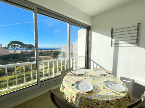 - une table sur un balcon avec vue sur l'océan dans l'établissement Studio cabine rénové avec ascenseur et parking, à 30m de la plage - FR-1-338-547, à Sète