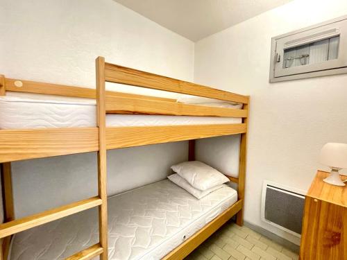 Cette chambre dispose de lits superposés, de 2 lits superposés et d'un bureau. dans l'établissement Studio cabine rénové avec ascenseur et parking, à 30m de la plage - FR-1-338-547, à Sète