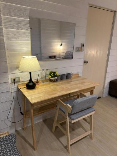 a wooden table with a lamp and a chair at La Locanda in Bangkok
