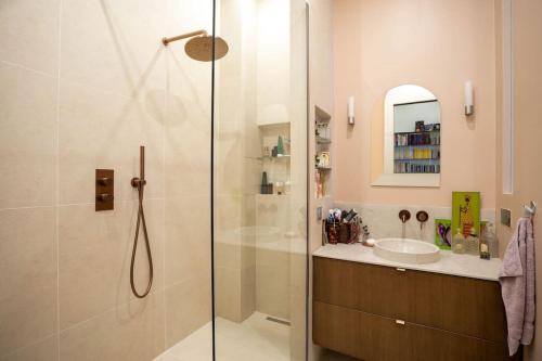 une salle de bain avec une douche en verre et un lavabo dans l'établissement Chic flat Place des Vosges, à Paris