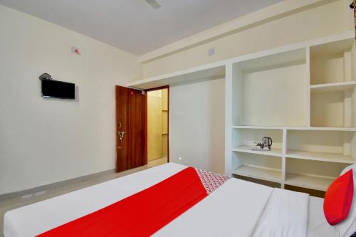 a bedroom with a red and white bed and shelves at Flagship Shivansh Palace in Bhubaneshwar