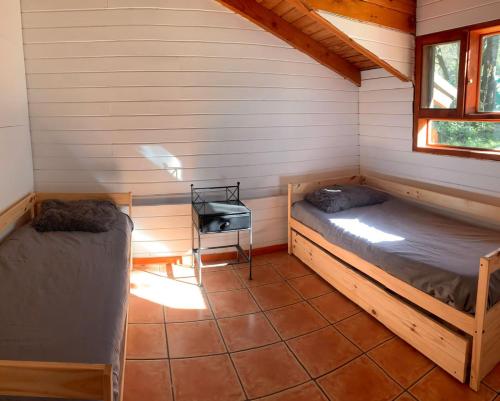 a room with two beds in a cabin at Casa Buena Vista in San Carlos de Bariloche