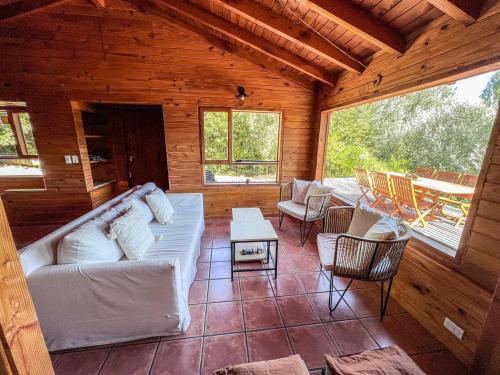 een woonkamer met een witte bank in een hut bij Casa Buena Vista in Bariloche
