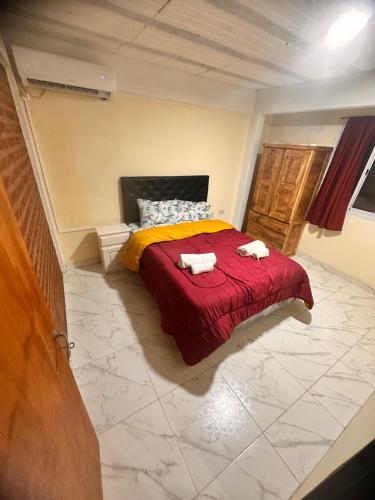 ein Schlafzimmer mit einem roten Bett mit zwei Handtüchern darauf in der Unterkunft Alojamiento Mia in Monte Grande