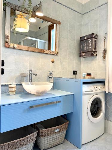 a bathroom with a sink and a washing machine at Borgo al Mare in Lido di Jesolo