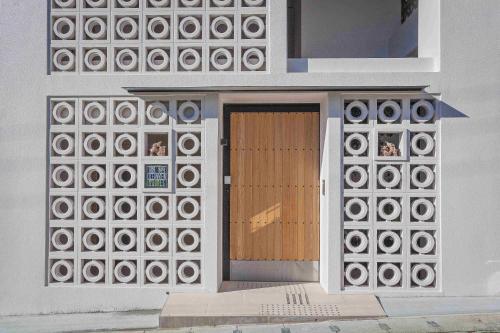 a building with a door with a bunch of windows at 恩納オーシャンビュースイート in Nakadomari