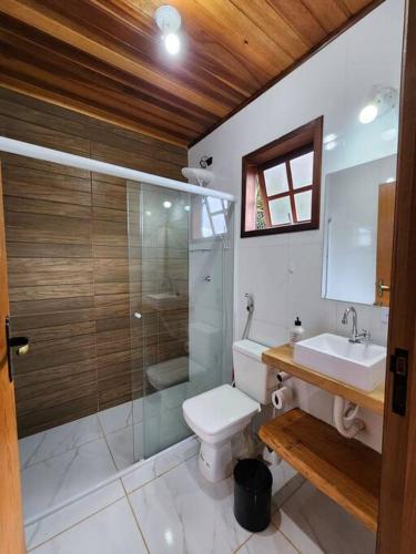 a bathroom with a shower and a toilet and a sink at Casa Da Floresta Cercada com Piscina in Santo Antônio do Pinhal