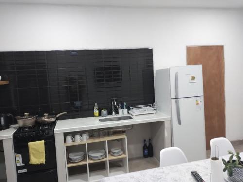 eine Küche mit einer Spüle und einem weißen Kühlschrank in der Unterkunft Nanai in Cafayate