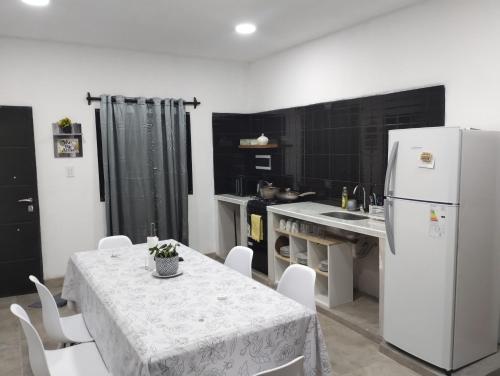 eine Küche mit einem Tisch und einem weißen Kühlschrank in der Unterkunft Nanai in Cafayate