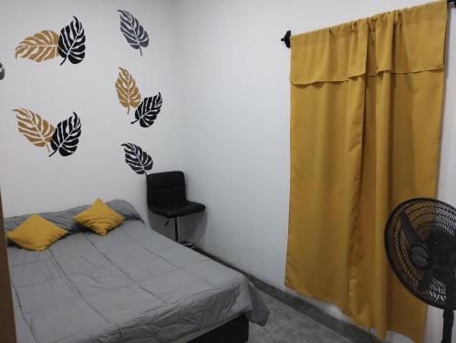 1 dormitorio con 1 cama con hojas en la pared en Nanai en Cafayate