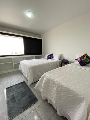 1 dormitorio con 2 camas y ventana grande en MARINA MAR, en Caraguatatuba