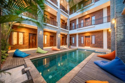 an indoor pool in a building with blue and orange pillows at Gelatik Bed And Breakfast in Seminyak