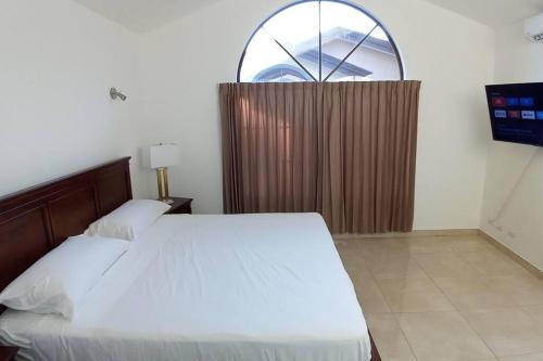 Ciudad Cariari的住宿－7H Entire Condo Near Cariari Golf club and SJO，一间卧室设有一张床和一个大窗户