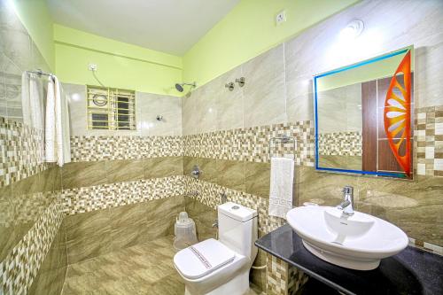 RedKEY Inn Bangalore Airport - Pick up & Drop Available 24x7 في Yelahanka: حمام به مرحاض أبيض ومغسلة