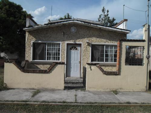 una pequeña casa de piedra con puerta blanca en Casita en Ticuman, en Ticumán