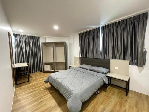 1 dormitorio con 1 cama grande en una habitación con ventanas en The Executive Apartment @ Kuching City Mall, en Kuching