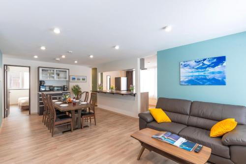 a living room and dining room with a couch and a table at FuranoSky - White in Furano
