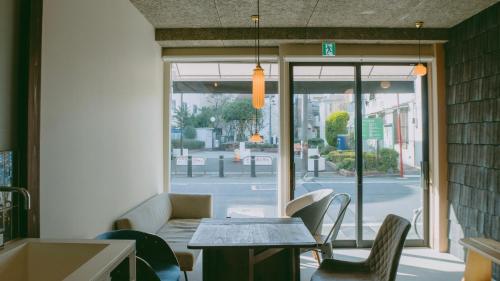 un restaurant avec une table, des chaises et une fenêtre dans l'établissement Sumida Nagaya, à Tokyo