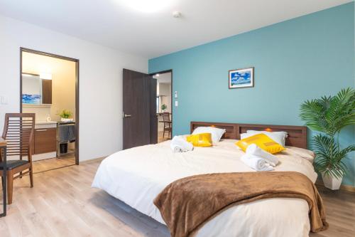 a bedroom with a large white bed with yellow pillows at FuranoSky - Blue in Furano