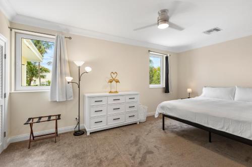 a bedroom with a white bed and two windows at Paradise Six in Creek Village