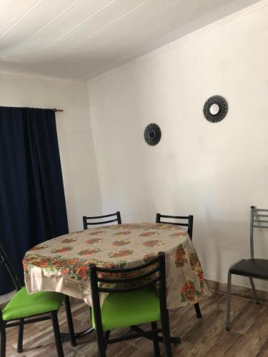 einen Tisch mit 2 Stühlen und einen Tisch mit einer Tischdecke in der Unterkunft Departamento “Costa Azul” Monte Hermoso in Monte Hermoso