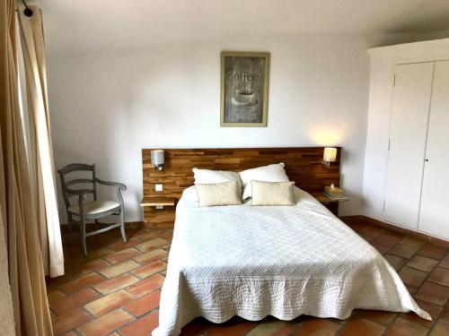 une chambre avec un lit blanc et une chaise dans l'établissement Petite villa 4 pers, plage à 1 km, tout confort, animaux acceptés - FR-1-768-64, aux Issambres