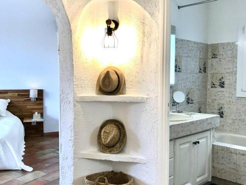 La salle de bains est pourvue d'un lavabo et d'un chapeau sur une étagère. dans l'établissement Petite villa 4 pers, plage à 1 km, tout confort, animaux acceptés - FR-1-768-64, aux Issambres