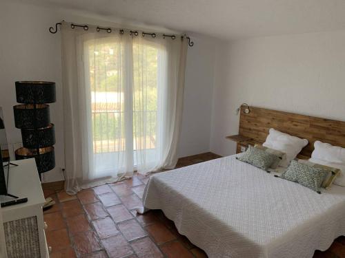 une chambre avec un lit et une grande fenêtre dans l'établissement Villa T2 climatisée avec jardin, proche plage, parking et animaux acceptés - FR-1-768-65, aux Issambres
