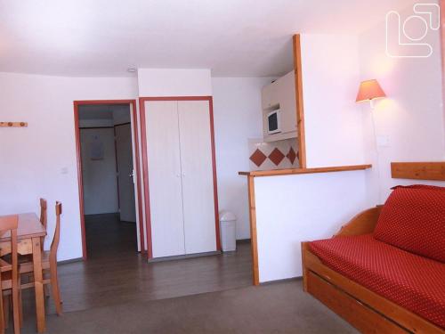 un salon avec un canapé rouge et une table dans l'établissement Appartement 2P, 6 Pers, Balcon Sud/Est, À 100m des Pistes et Commerces - L'Alpe d'Huez - FR-1-405-351, à Huez