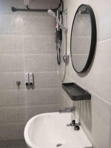 a bathroom with a sink and a mirror at Auliya Homestay Melaka Seaview Pantai Puteri in Melaka