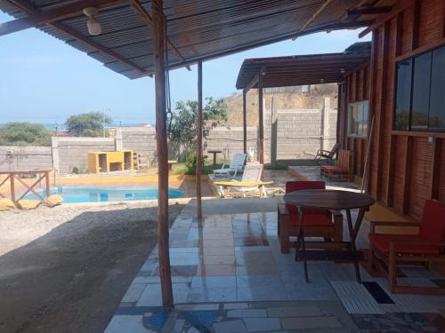 a patio with a table and chairs and a pool at Bonanza Beach House Zorritos in Bocapán