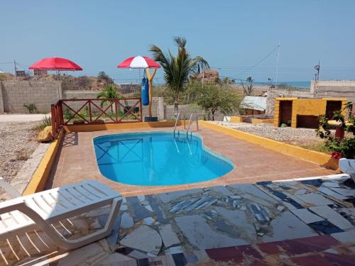 Bocapán的住宿－Bonanza Beach House Zorritos，一个带椅子和遮阳伞的游泳池