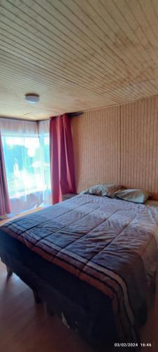 a bedroom with a large bed with red curtains at Casa LLanquihue in Llanquihue