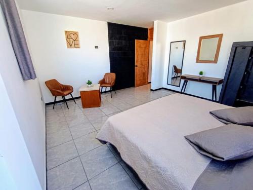 a bedroom with a bed and a table and chairs at Departamento Nuevo Suite Máster in Aguascalientes
