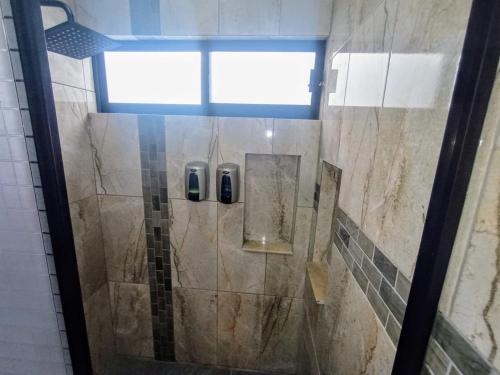 um chuveiro com uma porta de vidro na casa de banho em Departamento Nuevo Suite Máster em Aguascalientes