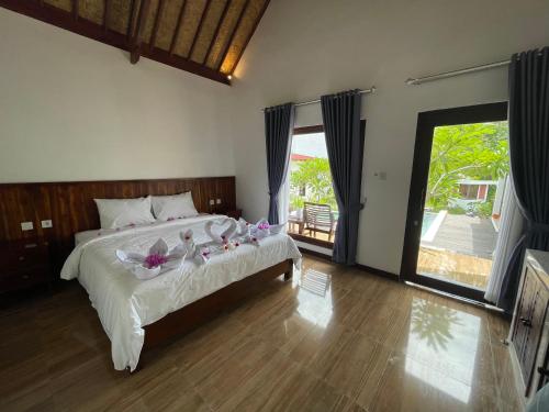 een slaapkamer met een groot bed met bloemen erop bij The Local Are Guling in Kuta Lombok