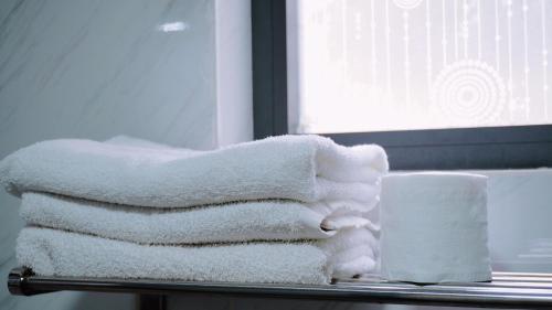 a pile of towels sitting on a shelf with a candle at Hoài Thu Hotel Vũng Tàu in Vung Tau