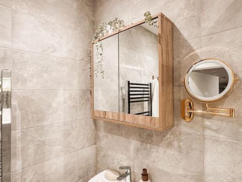 a bathroom with a mirror and a sink at Grand Union Apartment in Leicester