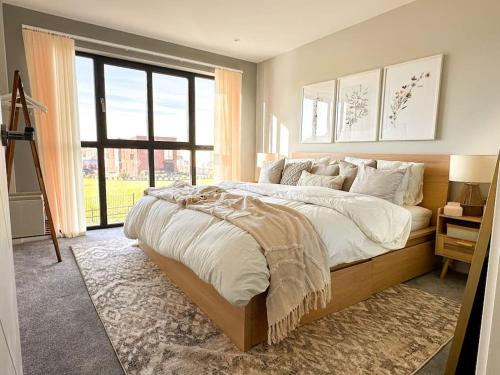 a bedroom with a large bed and a large window at Grand Union Apartment in Leicester