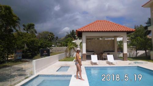 una mujer parada en el borde de una piscina en VP18, Lifestyle All Inklusive , Villapark, en Gurapito