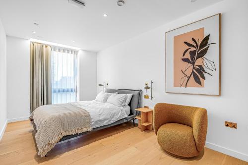 a bedroom with a bed and a chair and a window at Modern King's Cross Apartments in London