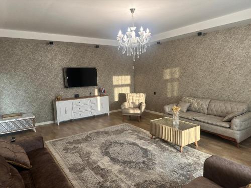 een woonkamer met een bank en een tv bij Дом у моря Мардакане in Mardakan